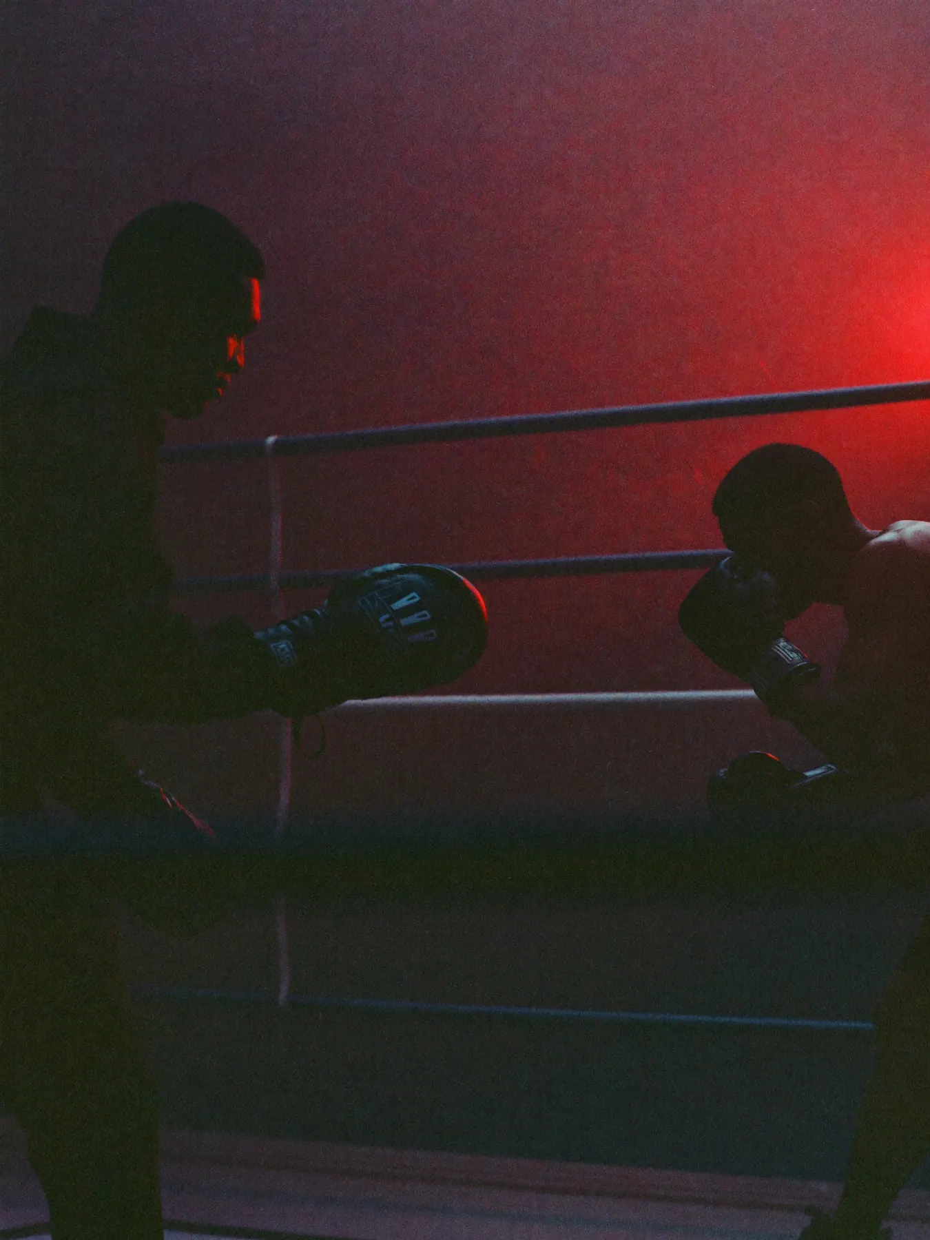 Entrenador con manoplas y boxeador lanzando un jab en el ring